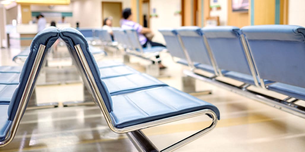 Rows of blue seating in a medical facility representing a healthcare client in a Strategic Benefits Advisors case study about resolving 401(k) compliance issues before a plan merger.