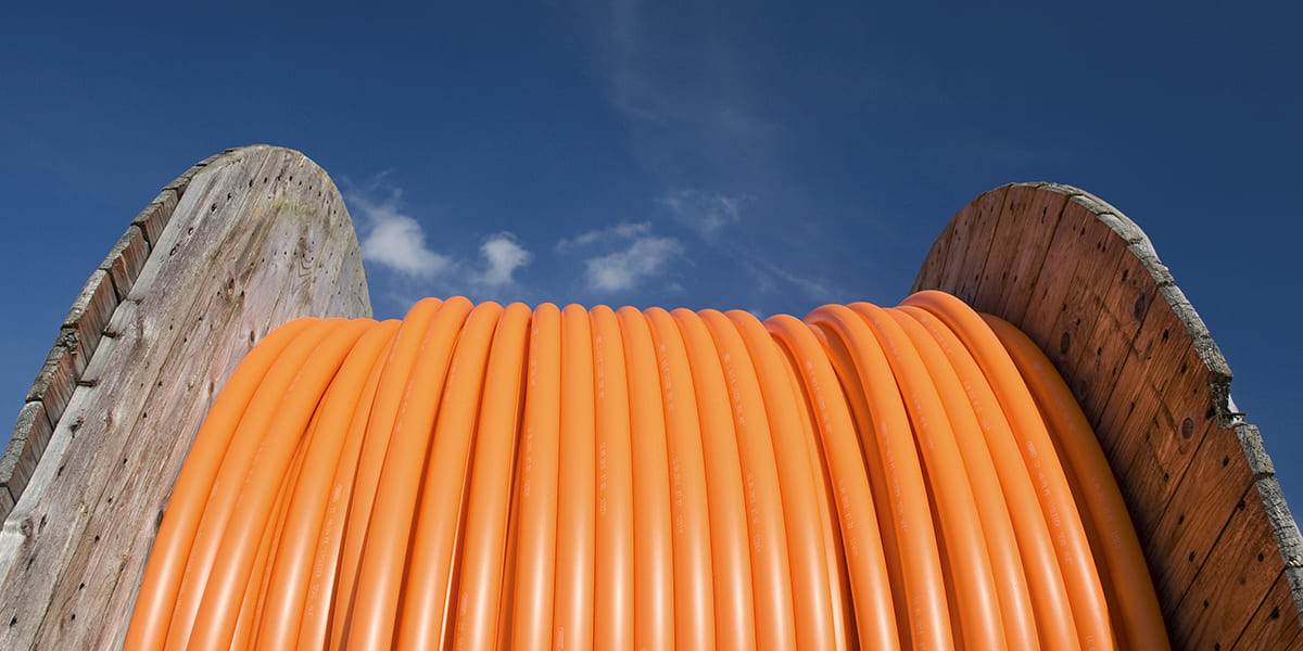 Large spool of orange telecommunications cabling representing a client in a Strategic Benefits Advisors case study on benefits due diligence for acquisitions.