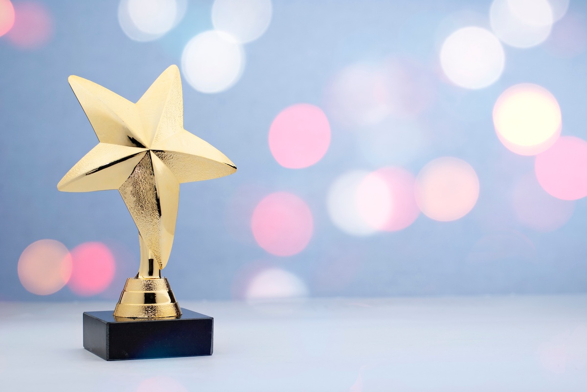 Strategic Benefits Advisors graphic celebrating senior consultant Andy Clonts' invitation to judge the 2025 Digital Health Awards, featuring a polished golden star trophy against a soft pastel bokeh background.