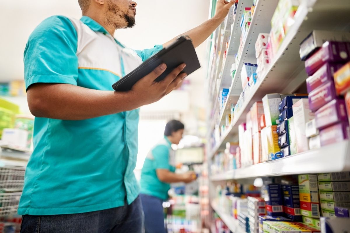 401(k) plan nondiscrimination testing after an acquisition for a supermarket corporation, featuring a grocery store worker checking inventory on a shelf while holding a tablet.