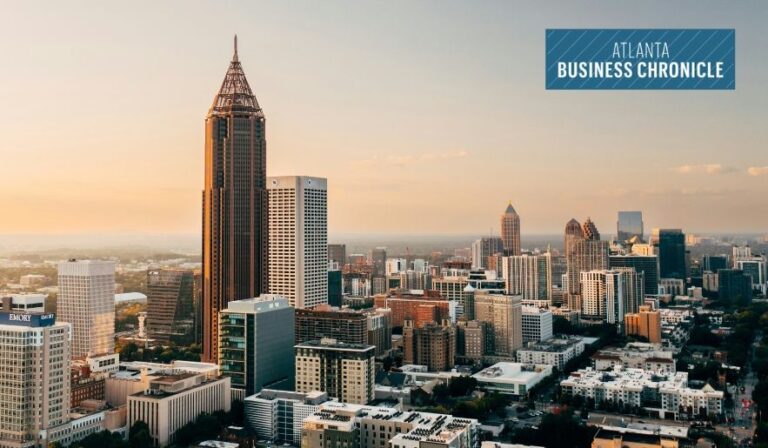 Aerial view of the Atlanta city skyline bathed in warm golden-hour sunlight, featuring Bank of America Plaza, with the Atlanta Business Chronicle logo in the top-right corner.