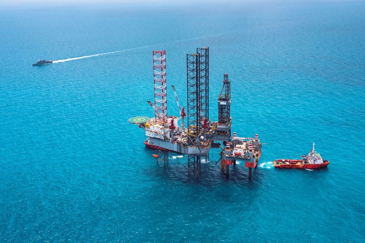 Strategic Benefits Advisors case study image depicting an offshore oil and gas drilling rig operating in bright blue ocean waters, surrounded by service vessels.